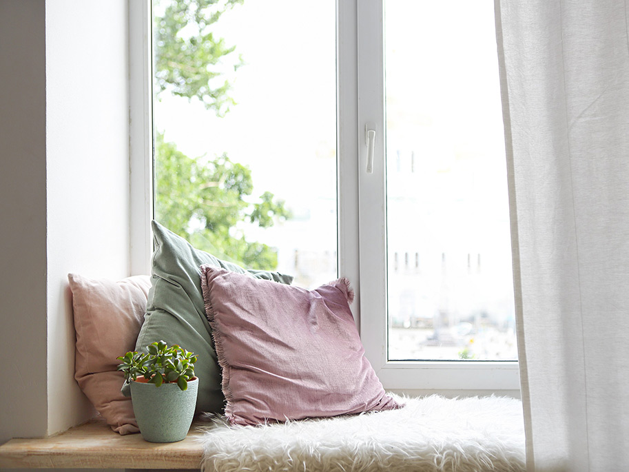 Fensterbank mit Kissen und Decke