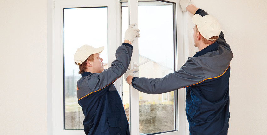 Zwei Handwerker montieren ein Fenster